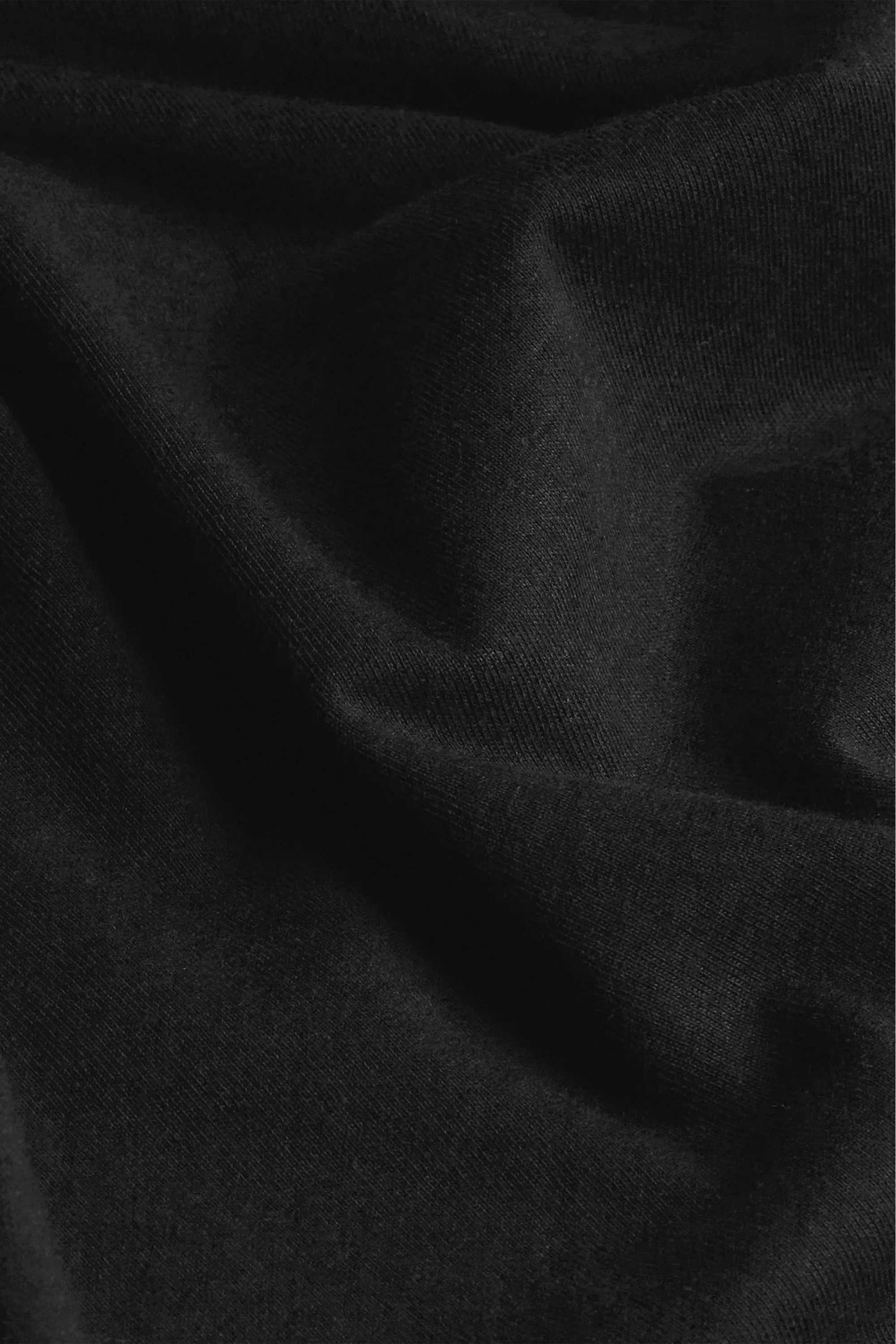 Detalhe do algodão puro da Camiseta Essencial Preta — maciez e durabilidade Textura do tecido em algodão 100% natural da Camiseta Essencial Preta