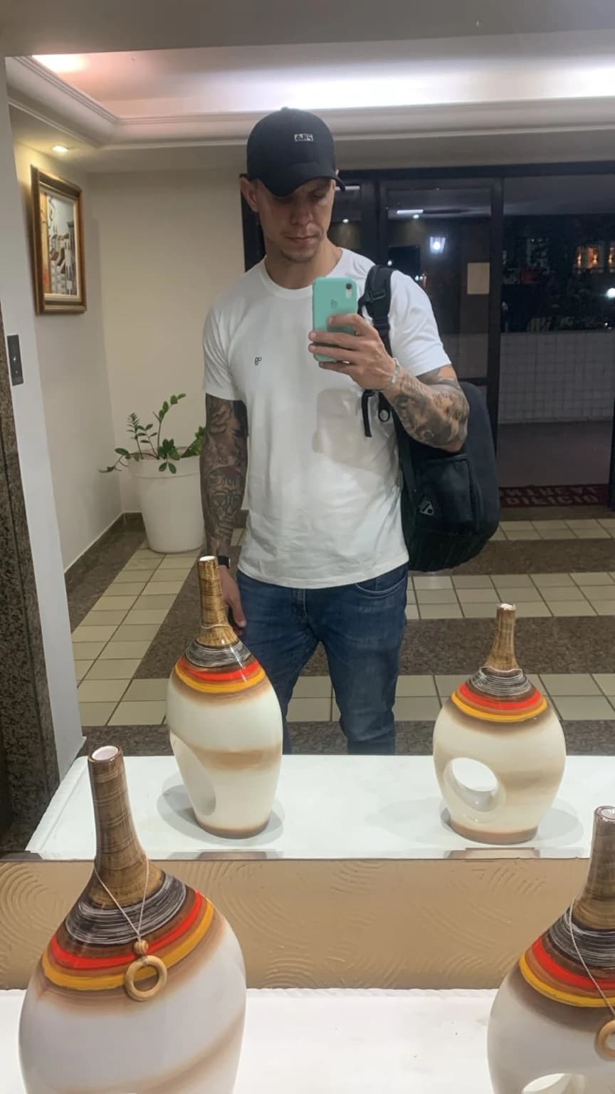 Augusto P. usando camiseta branca da OITONOVE no espelho